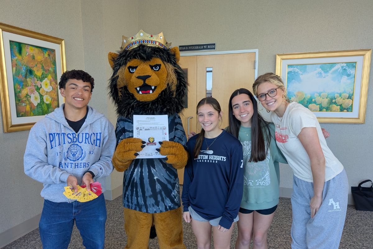 students with Leo the Lion while earning Monarch Moolah during a Monopoly-inspired game