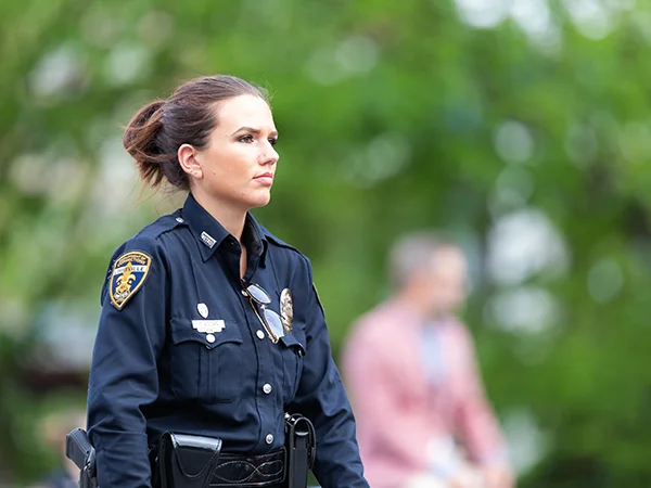a police officer with a criminal justice degree posing in their uniform