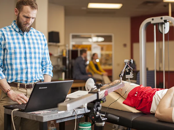professor using exercise science equipment, an example of exercise science major jobs