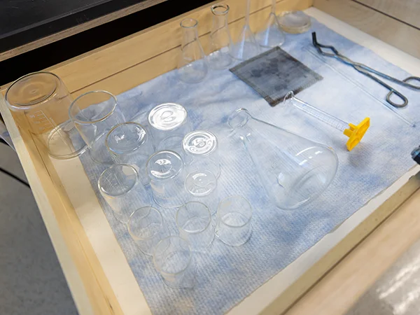 An assortment of empty beakers, cylinders, and jars
