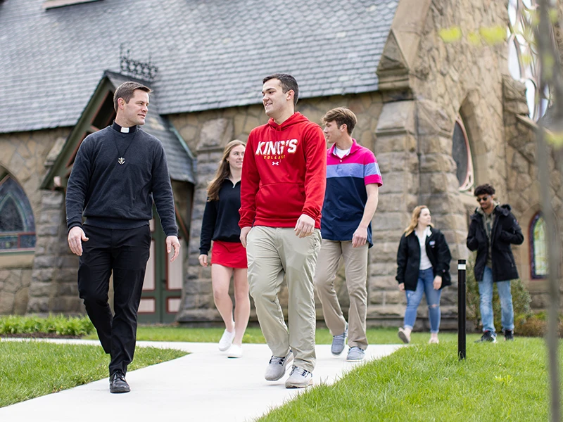 a priest walks in tandem with several students outside the Chapel, a frequent occurrence at a Catholic college in pa.