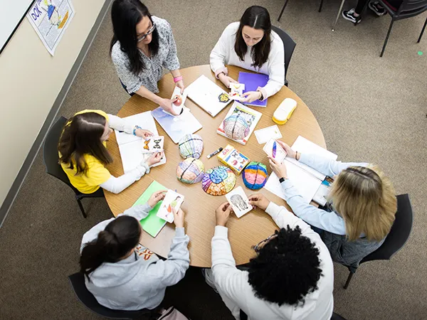 teachers meeting at a round table in a classroom, a professional development for teachers example